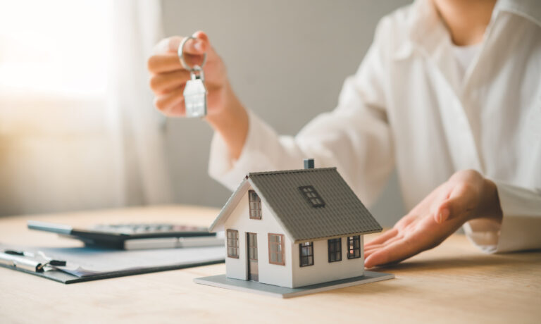 Salesperson Concept of holding house keys, house keys for a new home, new home purchase. a loan agreement for real estate, a loan deal for real estate, a loan agreement for real estate